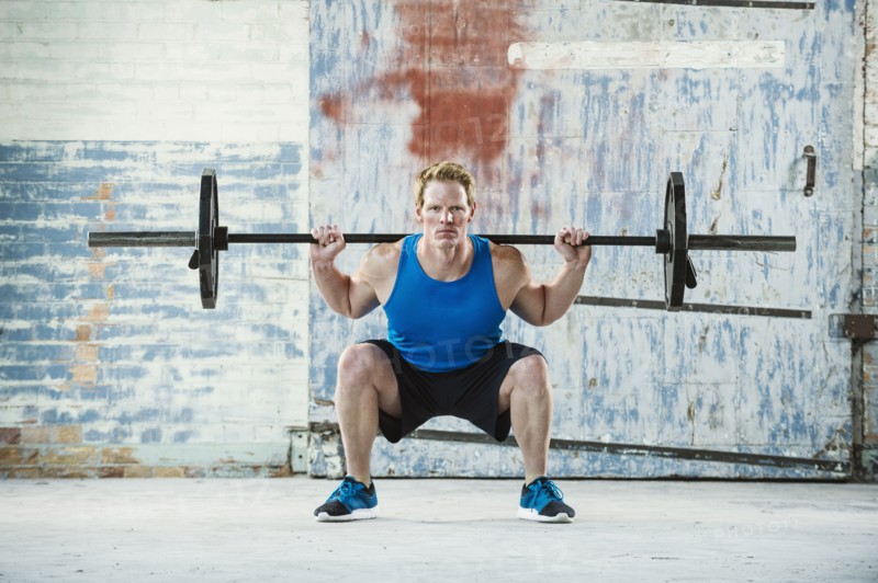 Caucasian man lifting weights in warehouse