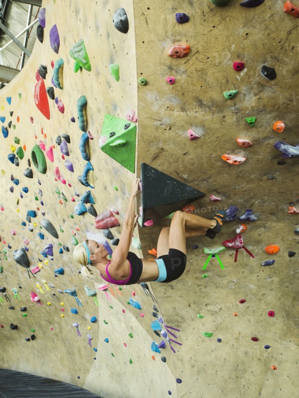 Caucasian woman climbing indoor rock wall