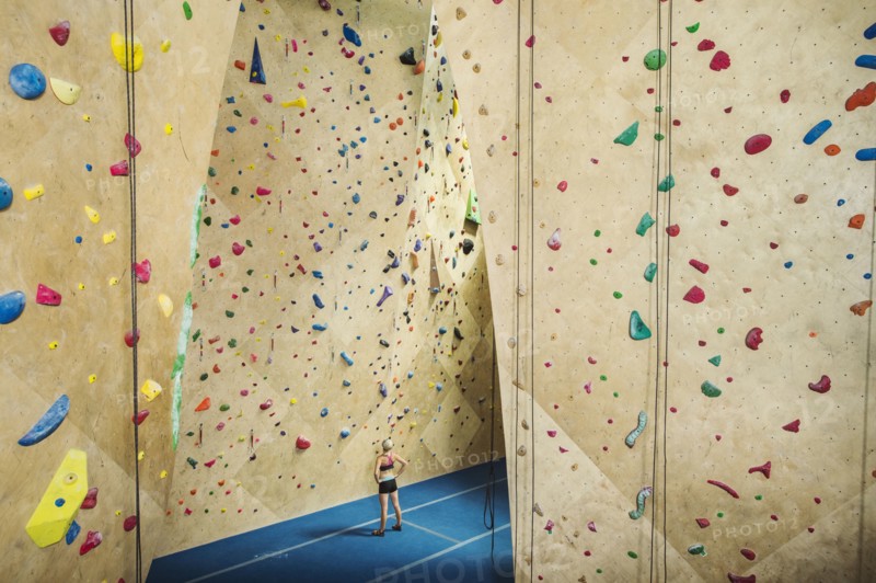 Caucasian woman examining indoor rock wall
