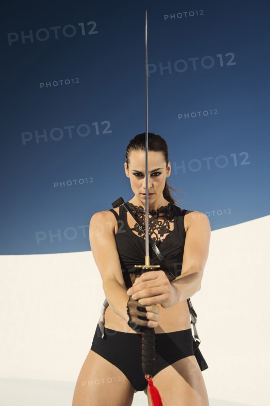 Caucasian woman posing with sword