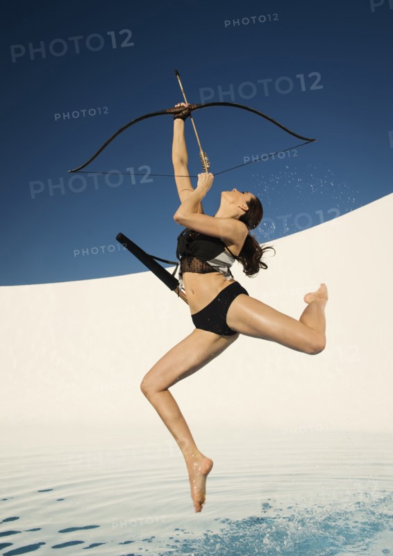 Caucasian woman aiming bow and arrow