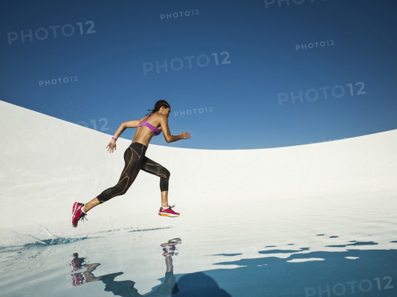 Mixed race woman running on water surface