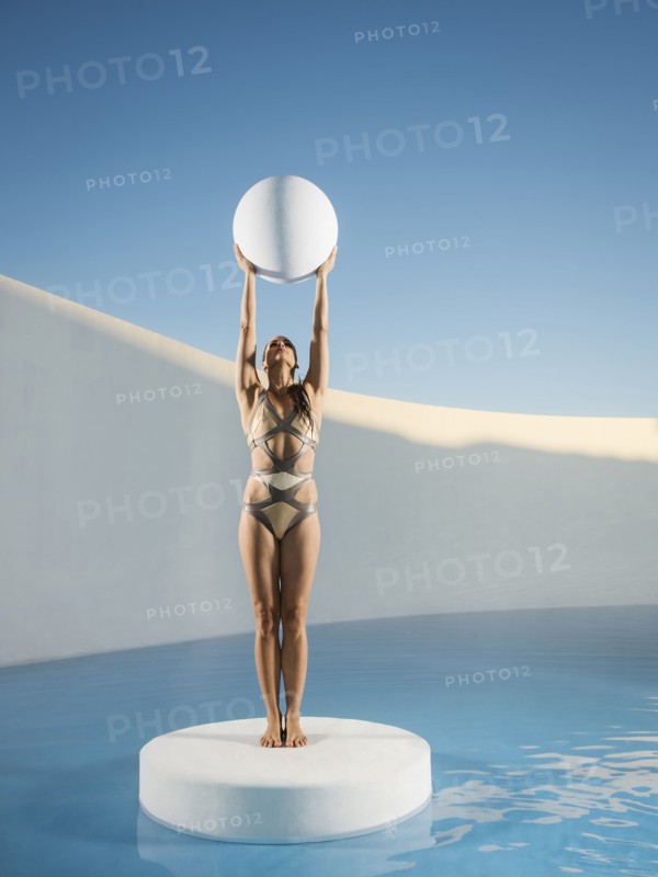 Caucasian woman holding sphere on ice floe