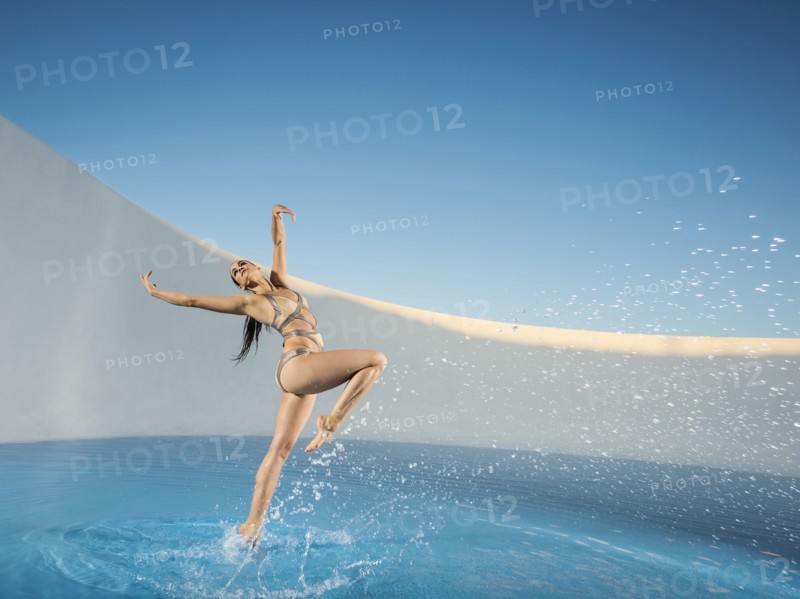 Caucasian woman dancing on swimming pool