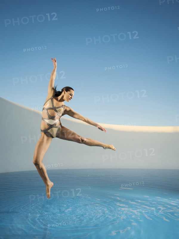 Caucasian woman dancing on swimming pool