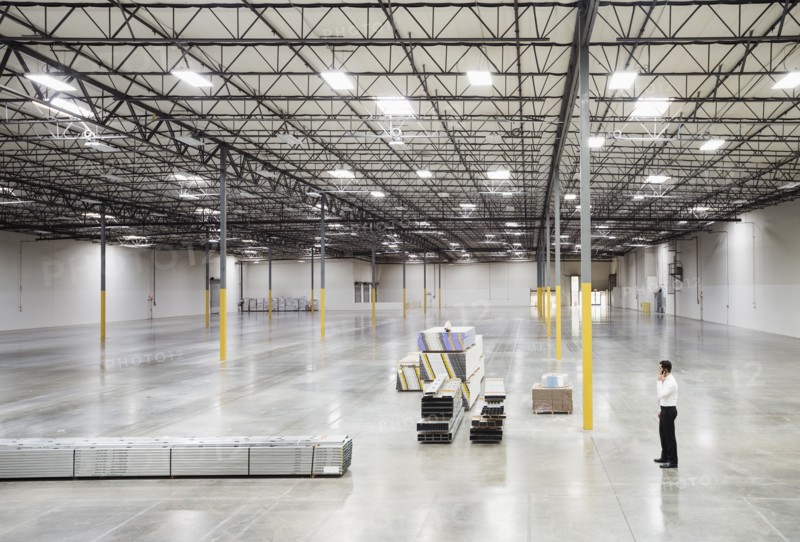 Caucasian businessman standing in empty warehouse