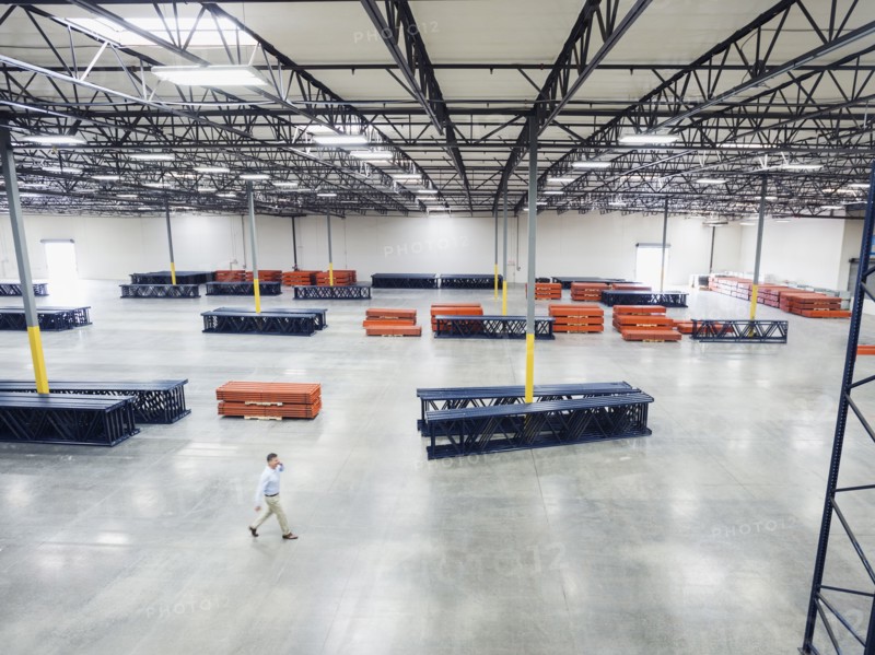 High angle view of Caucasian businessman walking in empty warehouse