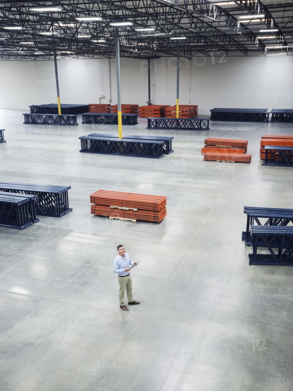 High angle view of Caucasian businessman standing in empty warehouse