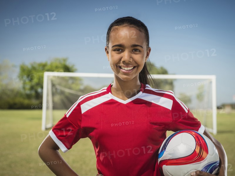 Mixed race soccer player standing on field