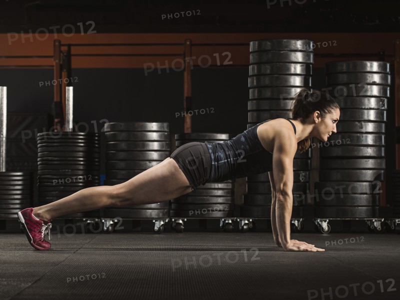 Caucasian athlete doing push-ups in gym