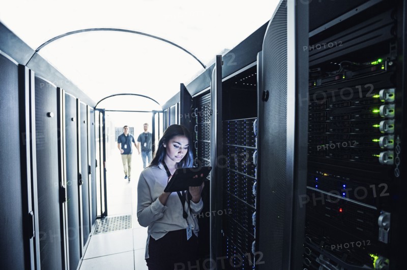 Technician using digital tablet in server room