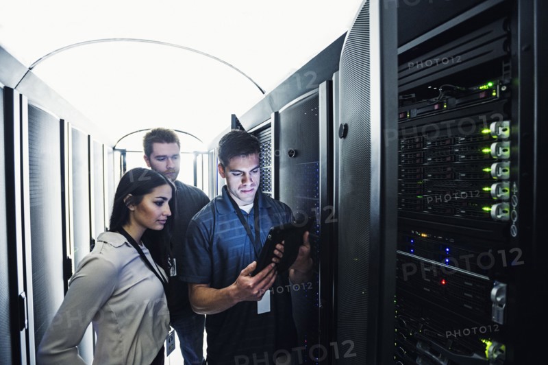 Technicians using digital tablet in server room