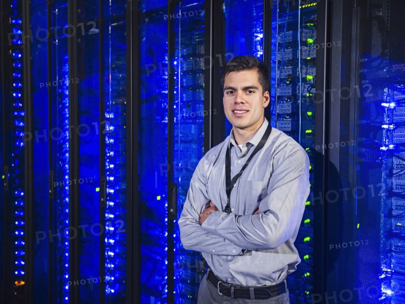 Hispanic technician smiling in server room