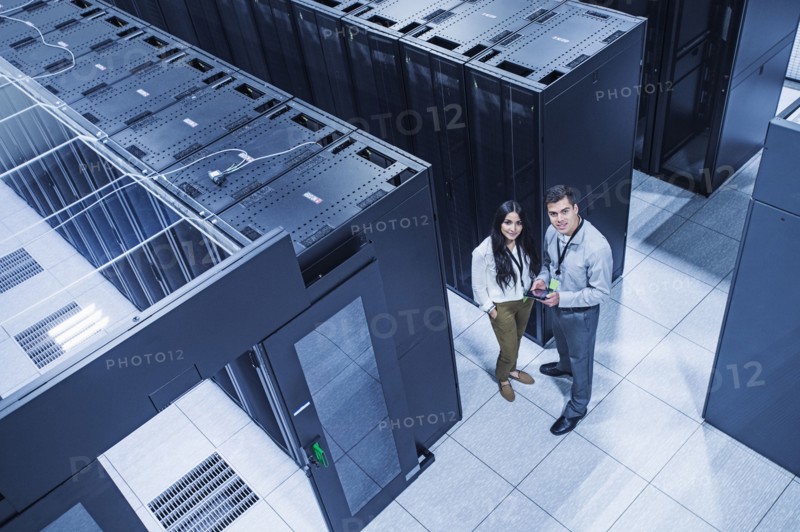 High angle view of technicians smiling in server room