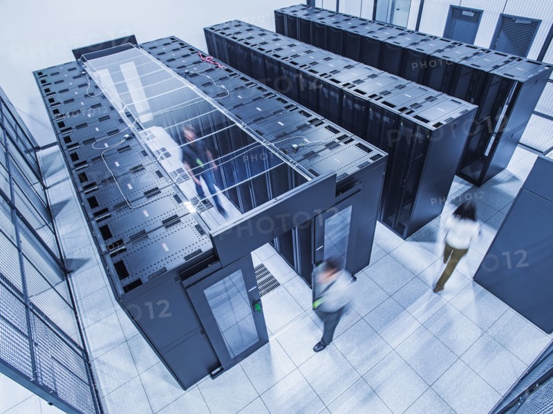 High angle view of technicians walking in server room