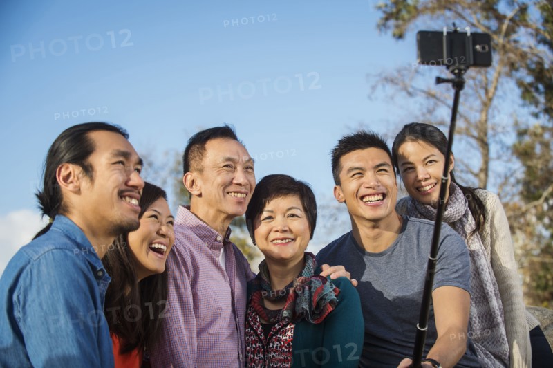 Chinese family taking photograph with selfie stick