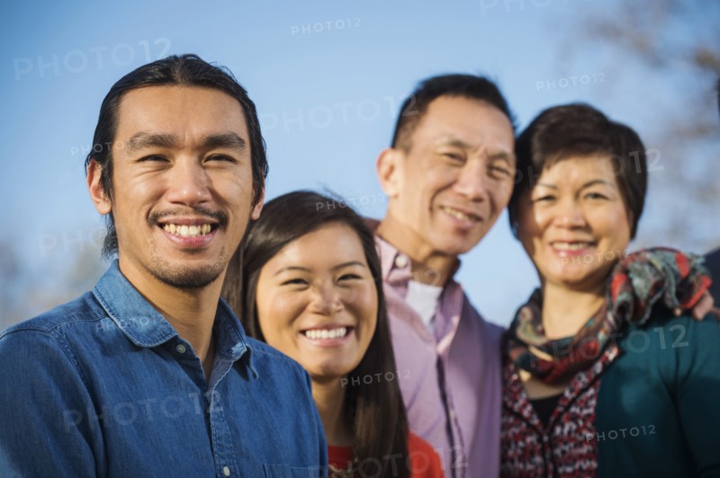 Chinese family smiling outdoors