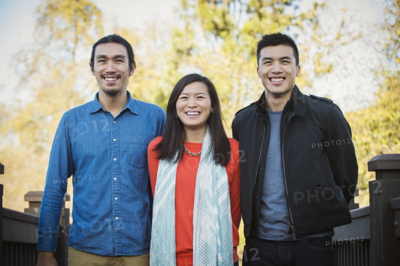Adult Chinese siblings smiling outdoors