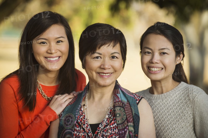 Chinese mother and daughters posing outdoors