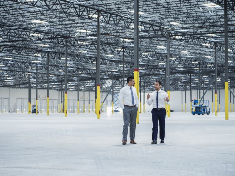 Businessmen talking in empty warehouse