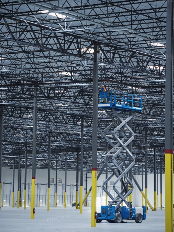 Indian worker on warehouse lift platform