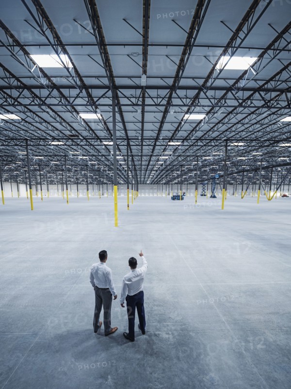 Businessmen talking in empty warehouse
