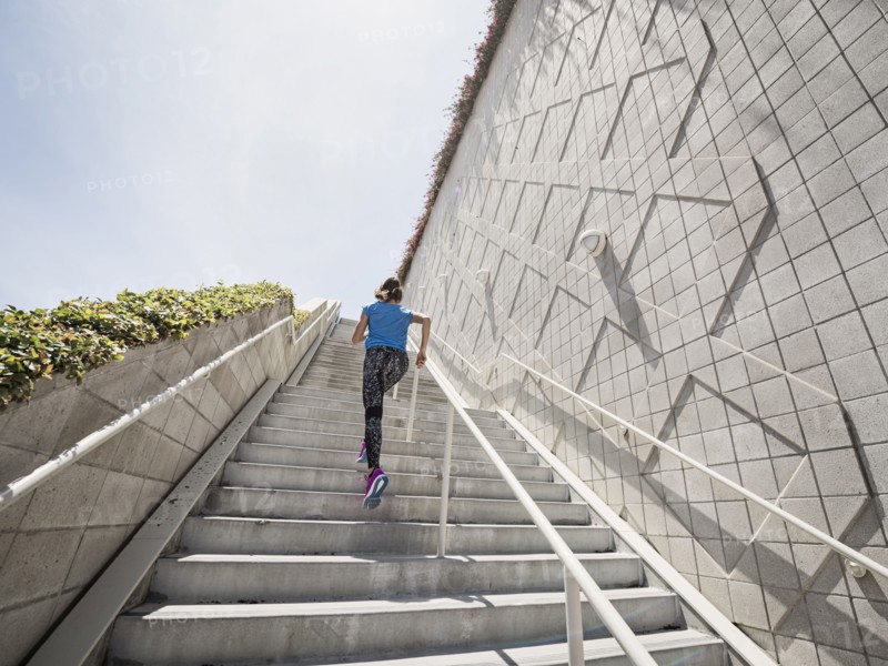 Caucasian woman running on staircase