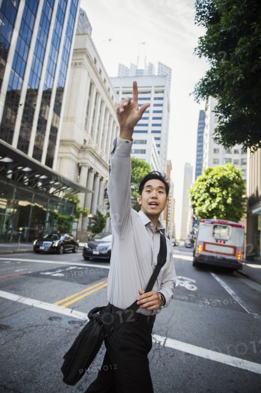 Chinese businessman hailing taxi in city