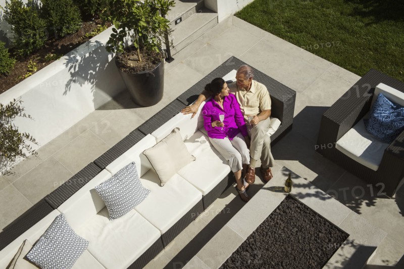 Older couple relaxing on modern backyard patio