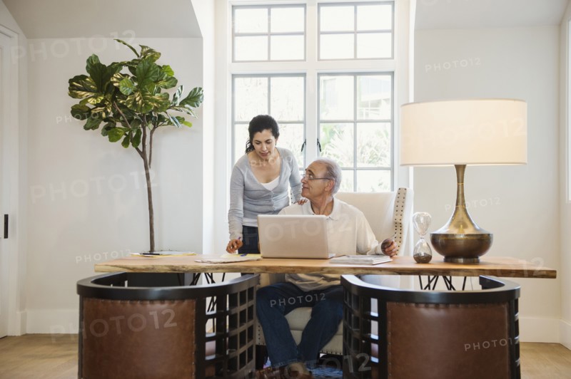Older couple using laptop in home office