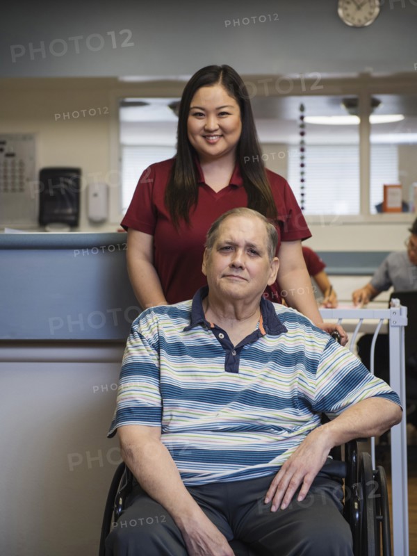 Portrait of smiling nurse and patient in wheelchair
