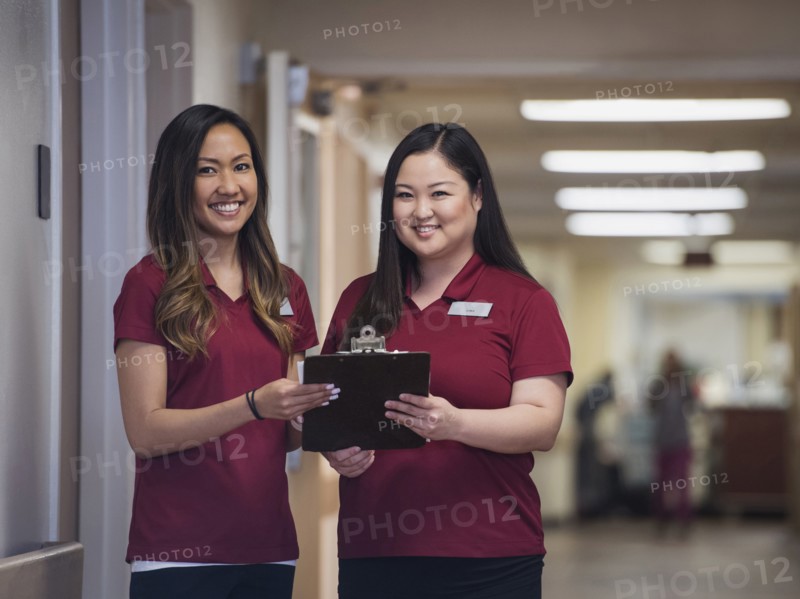 Smiling nurses holding clipboard in hospital