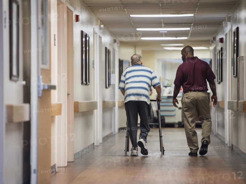 Nurse walking with patient using walker