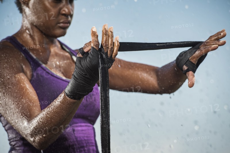 Black woman wrapping hands for boxing