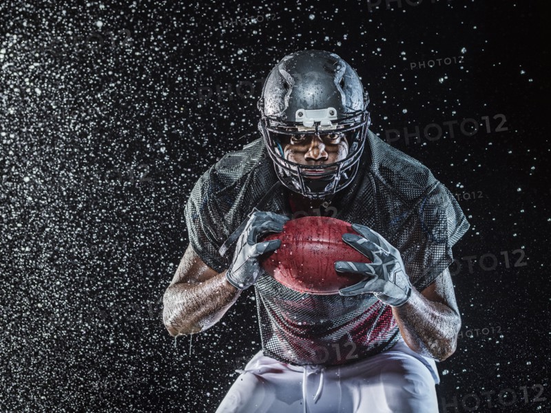 Water splashing on black football player