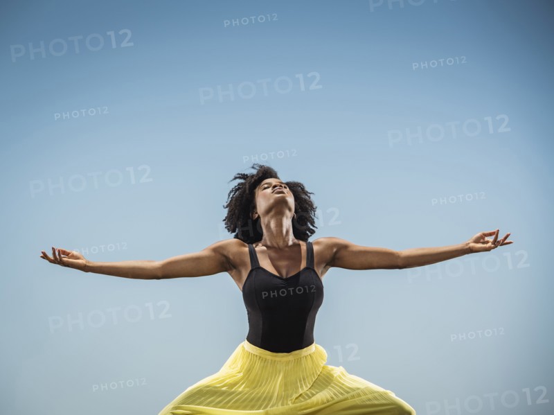 Black woman dancing with arms outstretched