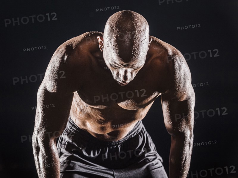 Sweating Black man bending and resting