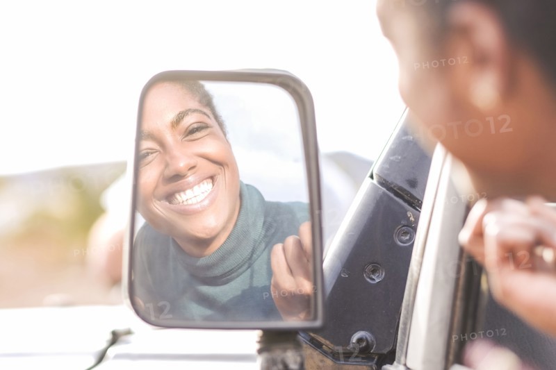 Reflection of African American woman in car mirror