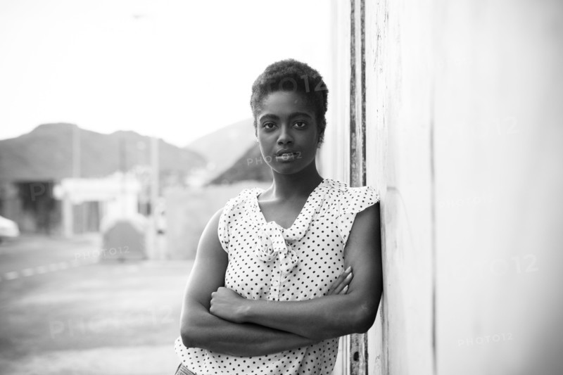 Serious African American woman leaning on wall