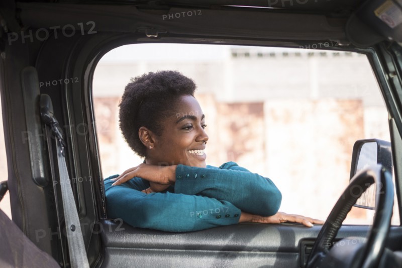 Smiling African American woman leaning on car window