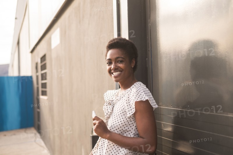 Smiling African American woman holding cell phone