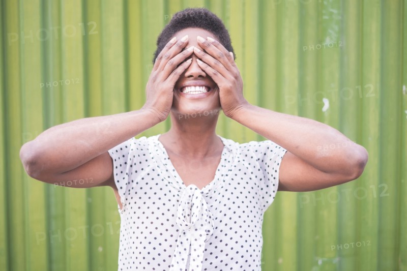 Smiling African American woman covering eyes