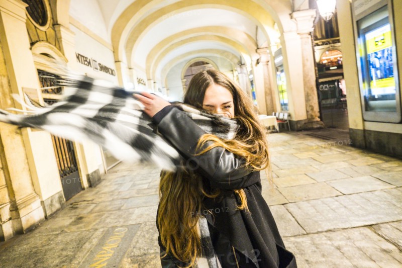 Caucasian couple tossing scarf in lobby