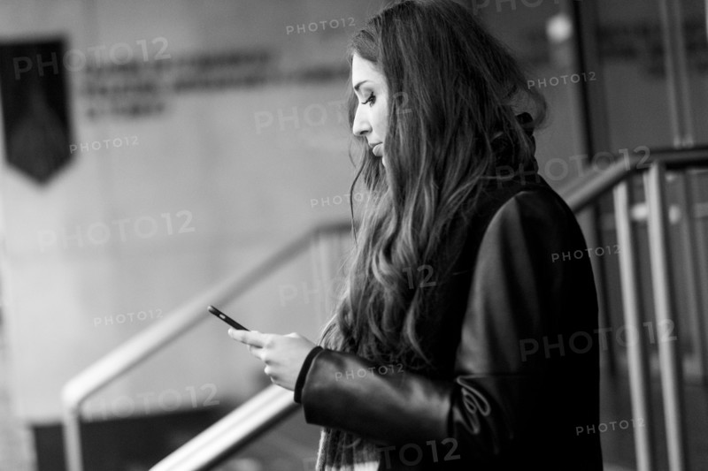 Serious Caucasian woman texting on cell phone