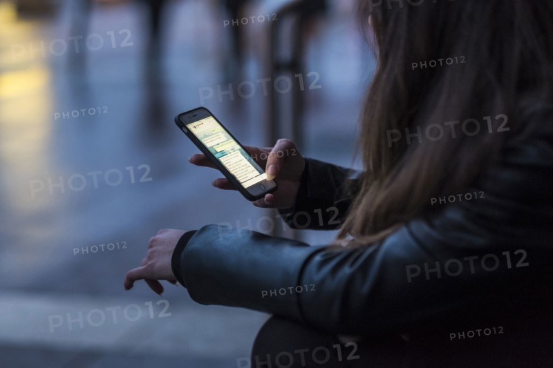 Caucasian woman texting on cell phone outdoors