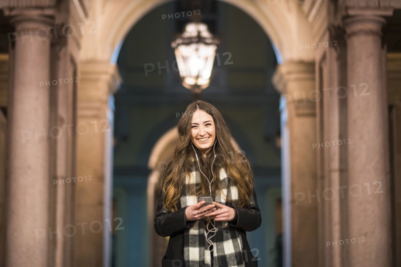 Smiling Caucasian woman listening to music on cell phone