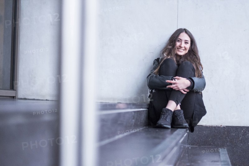 Smiling Caucasian woman sitting on staircase