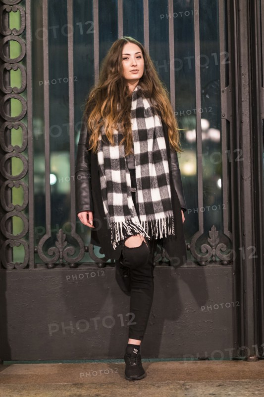Portrait of serious Caucasian woman leaning on gate