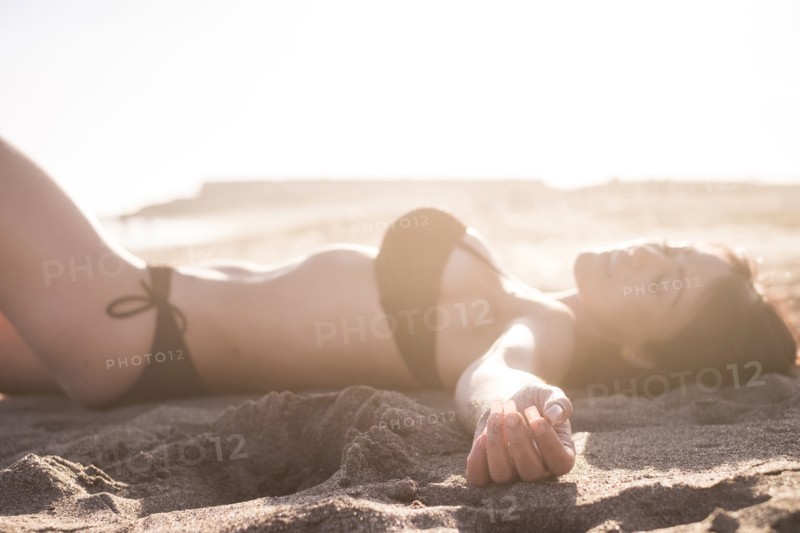 Caucasian woman sunbathing on beach
