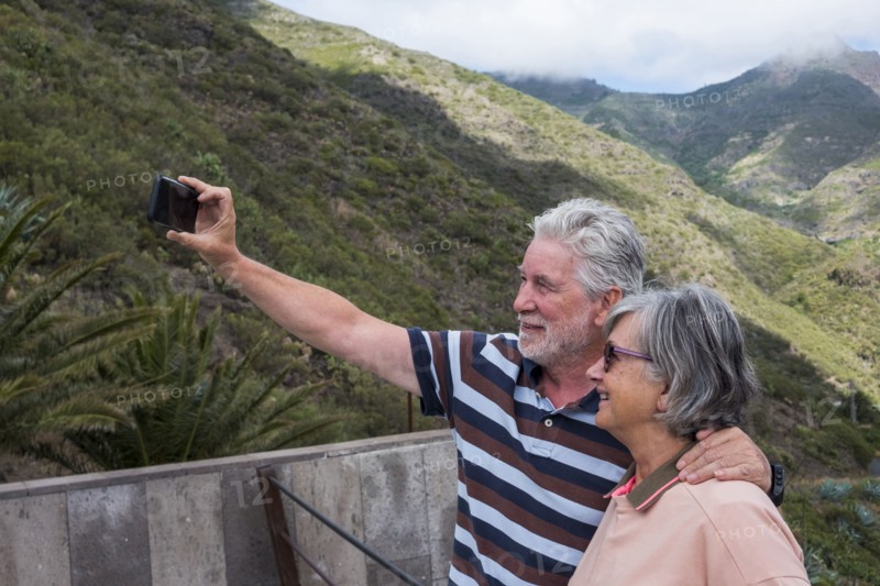Older Caucasian couples posing for cell phone selfie